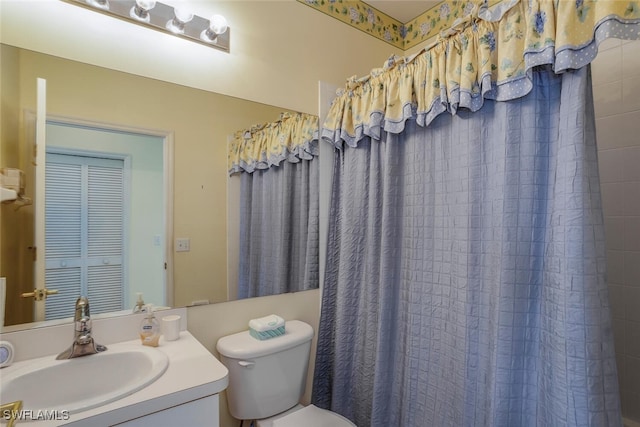 bathroom with vanity, toilet, and curtained shower