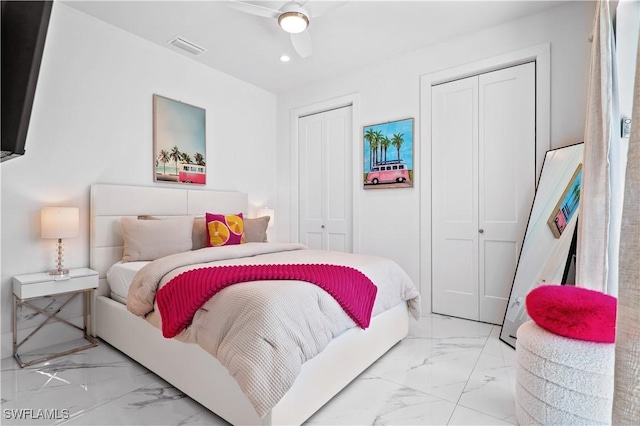 bedroom with ceiling fan and multiple closets