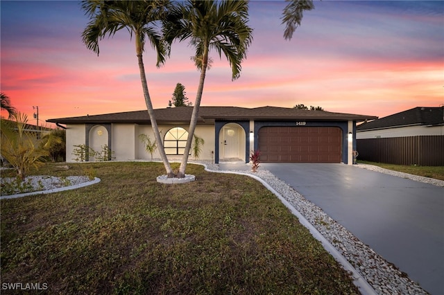 single story home with a garage and a lawn