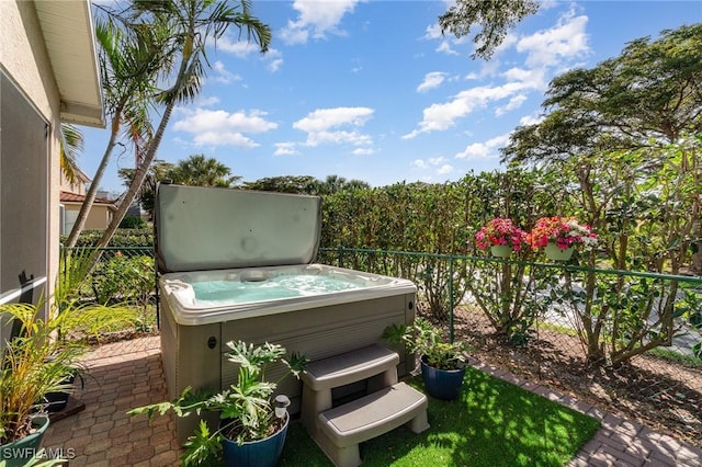 view of patio featuring fence and a hot tub