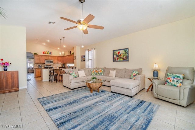 living room with ceiling fan, visible vents, vaulted ceiling, and light tile patterned flooring