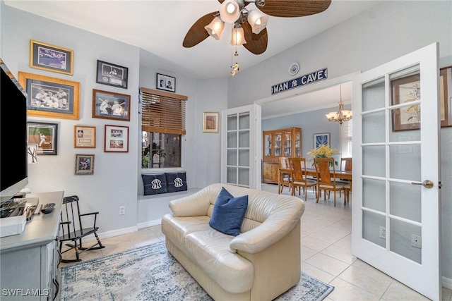 sitting room with light tile patterned floors, french doors, ceiling fan with notable chandelier, and baseboards