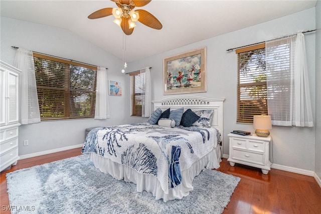 bedroom featuring dark wood-style flooring, vaulted ceiling, baseboards, and ceiling fan