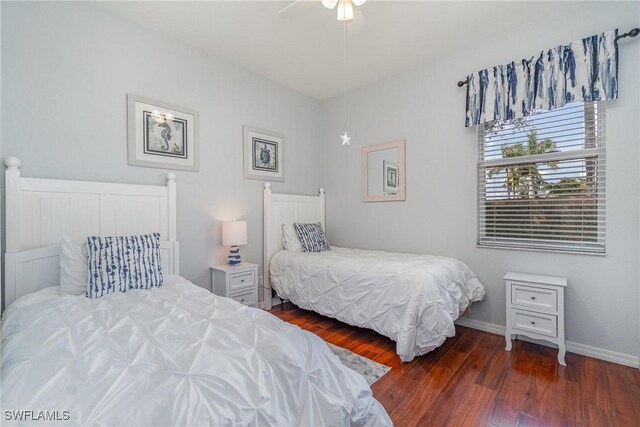 bedroom with baseboards and dark wood-type flooring