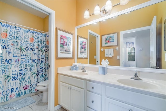 full bath with double vanity, a sink, toilet, and tile patterned floors