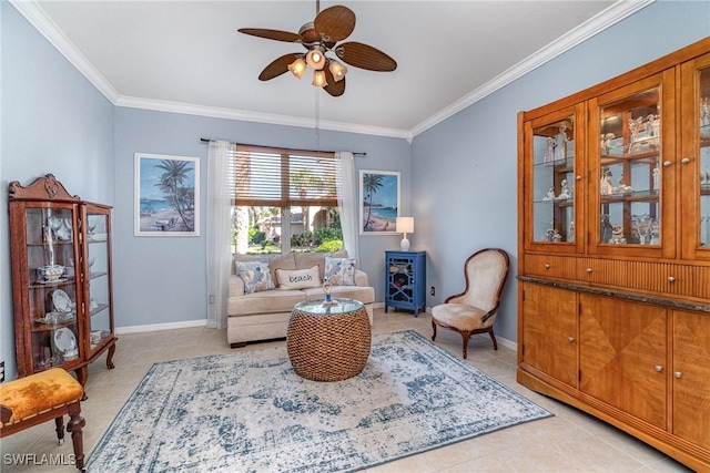 sitting room with light tile patterned floors, ceiling fan, baseboards, and crown molding