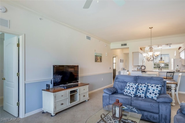 living room with ornamental molding, sink, and ceiling fan with notable chandelier