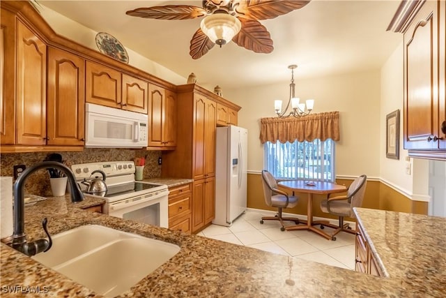 725 Saratoga Cir Unit A103, Naples, FL 34104 - kitchen featuring light tile patterned floors, a sink, white appliances, brown cabinetry, and ceiling fan with notable chandelier