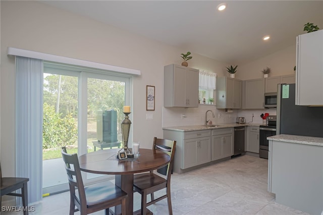 kitchen featuring stainless steel appliances, plenty of natural light, gray cabinets, and backsplash