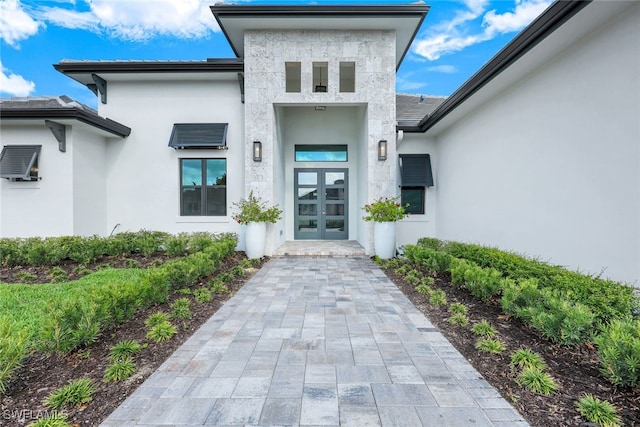 doorway to property featuring stucco siding and french doors