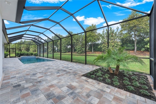 view of pool with a patio, glass enclosure, and a pool with connected hot tub