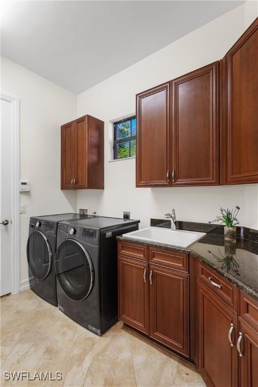 laundry area with cabinets, washer and dryer, and sink