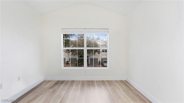 unfurnished room with lofted ceiling, light wood-style flooring, and baseboards