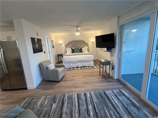 bedroom with hardwood / wood-style flooring, stainless steel refrigerator, and ceiling fan