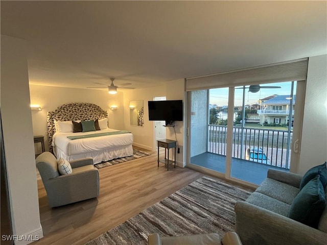 bedroom with hardwood / wood-style floors, access to outside, and ceiling fan