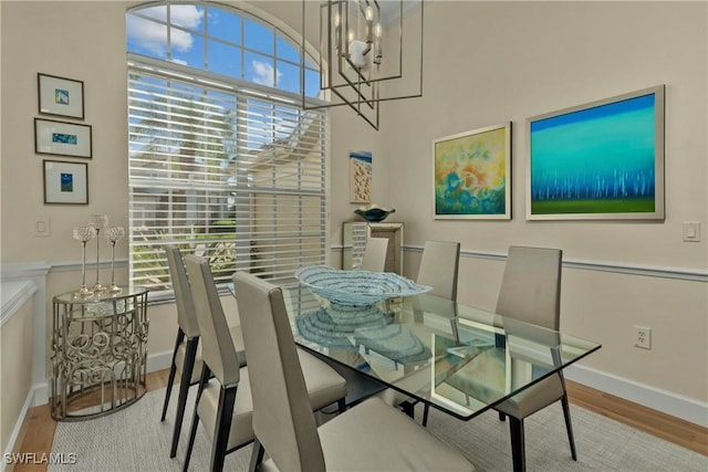 dining room with a notable chandelier, plenty of natural light, and light wood-type flooring