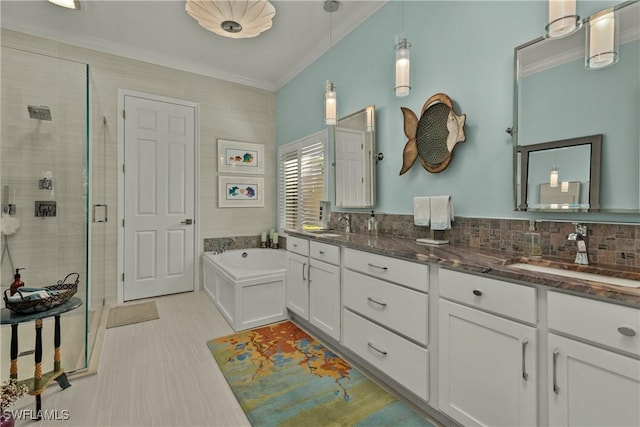 bathroom featuring vanity, backsplash, ornamental molding, and separate shower and tub