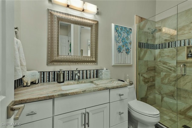 bathroom with vanity, a shower with shower door, and toilet