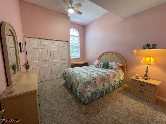 carpeted bedroom with ceiling fan, lofted ceiling, and a closet