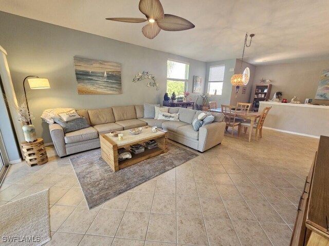 15495 Bellamar Cir Unit 2222, Fort Myers, FL 33908 - living room featuring light tile patterned floors, a ceiling fan, a chandelier, and baseboards
