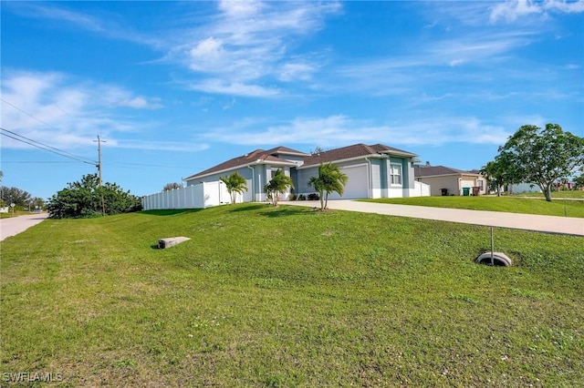 ranch-style house featuring a garage and a front lawn