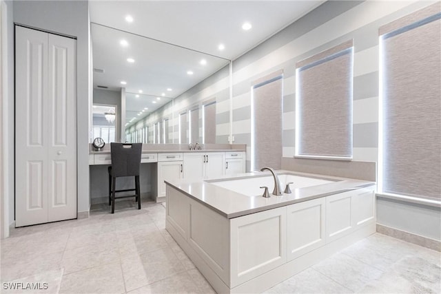 bathroom featuring vanity, tile patterned floors, and a tub