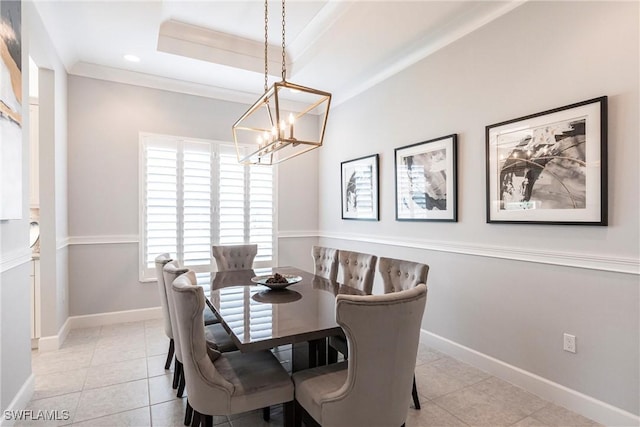 dining space with a raised ceiling, ornamental molding, light tile patterned floors, and an inviting chandelier