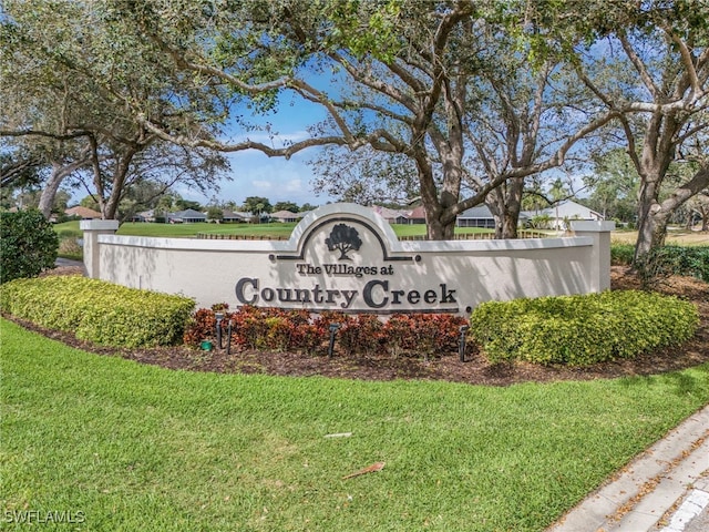 community / neighborhood sign featuring a yard