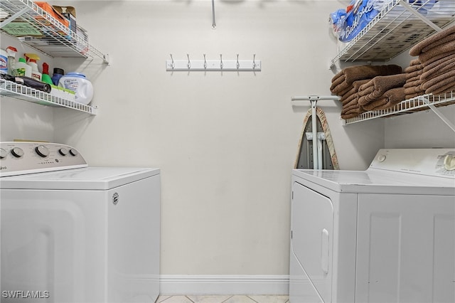 clothes washing area featuring separate washer and dryer and light tile patterned floors