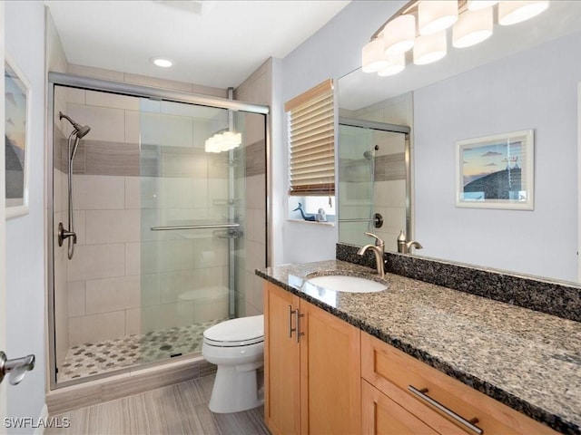 bathroom featuring vanity, an enclosed shower, and toilet