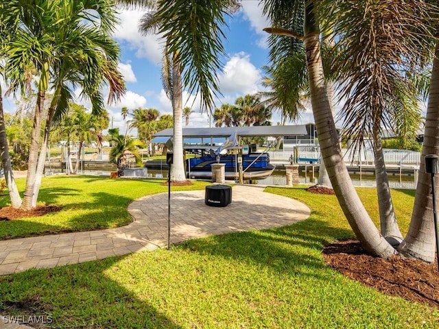 surrounding community featuring a yard, a boat dock, and a water view