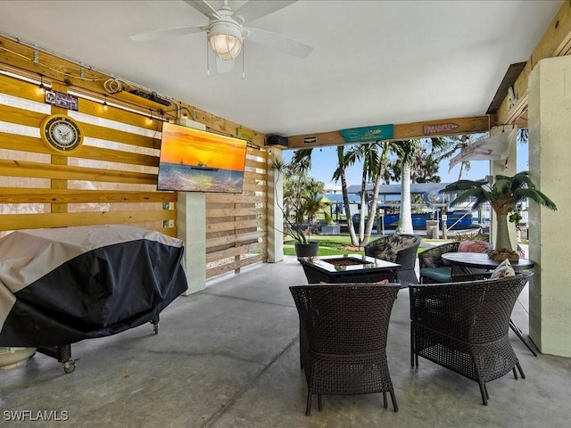 view of patio with area for grilling, ceiling fan, and a water view