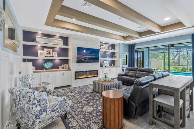 tiled living room featuring beamed ceiling, a tray ceiling, a fireplace, and built in shelves