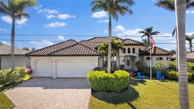 mediterranean / spanish-style house featuring a garage and a front lawn