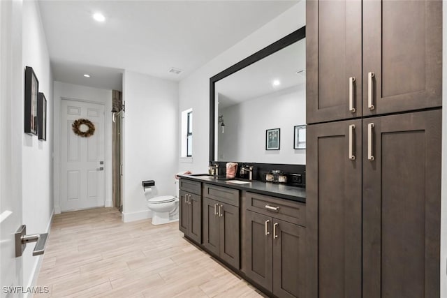 bathroom with vanity, toilet, and wood-type flooring