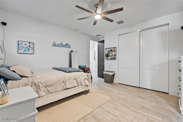 bedroom featuring ceiling fan, a closet, and light hardwood / wood-style flooring