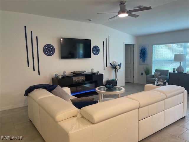 living room featuring vaulted ceiling, ceiling fan, and light tile patterned floors