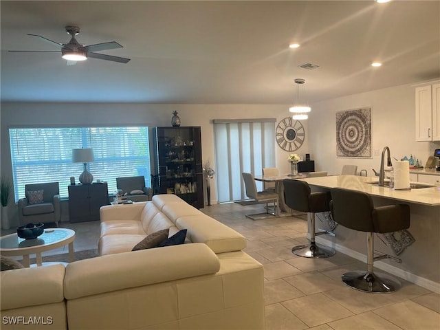 tiled living room with sink and ceiling fan