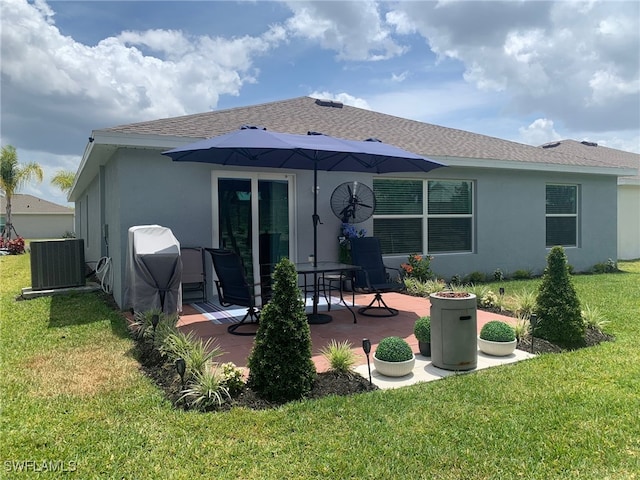 back of house featuring central AC unit, a lawn, and a patio area