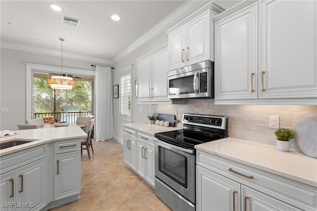 kitchen with white cabinetry, decorative backsplash, ornamental molding, and stainless steel appliances