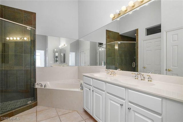 bathroom with a shower stall, a sink, a garden tub, and tile patterned floors