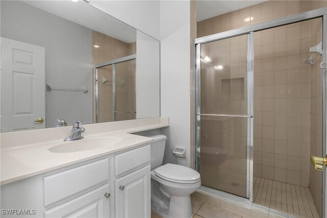 bathroom featuring vanity, a shower stall, and toilet