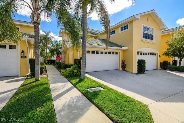 view of front of home featuring driveway, an attached garage, and stucco siding