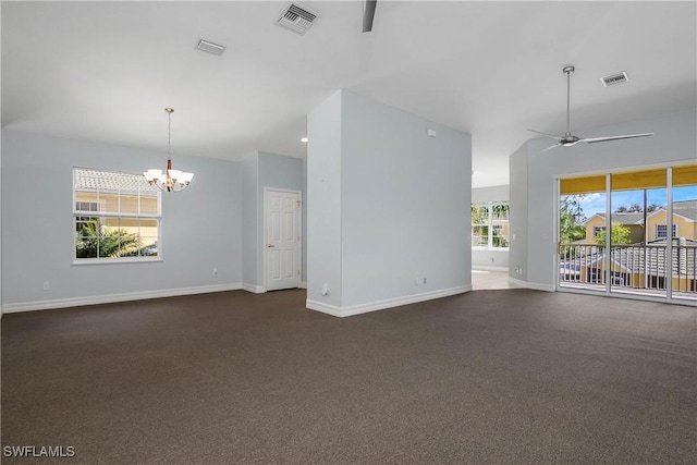 unfurnished living room featuring baseboards, visible vents, dark carpet, and ceiling fan with notable chandelier