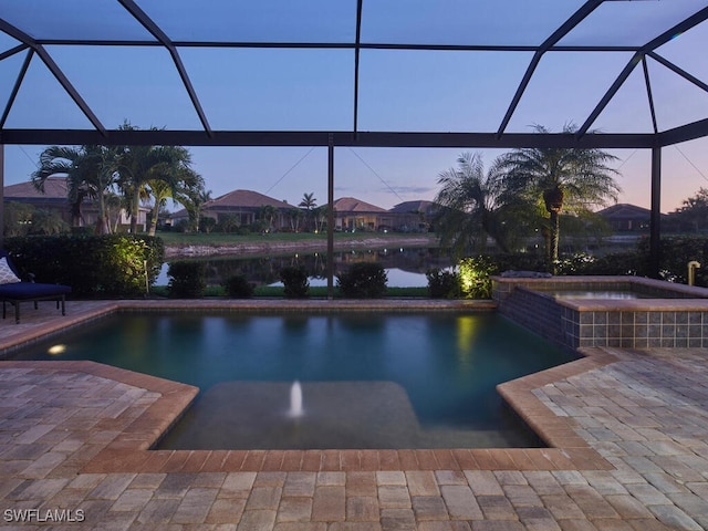 pool at dusk featuring a water view, an in ground hot tub, a lanai, and a patio area