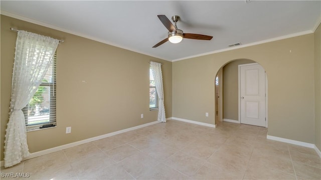 empty room featuring ornamental molding, visible vents, plenty of natural light, and arched walkways