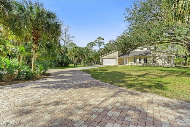 view of front facade featuring a garage, decorative driveway, and a front lawn