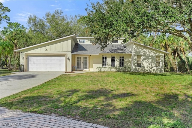 mid-century modern home featuring driveway, french doors, a front lawn, and an attached garage