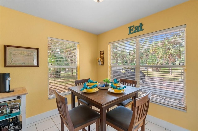 dining room with a wealth of natural light, baseboards, and light tile patterned floors