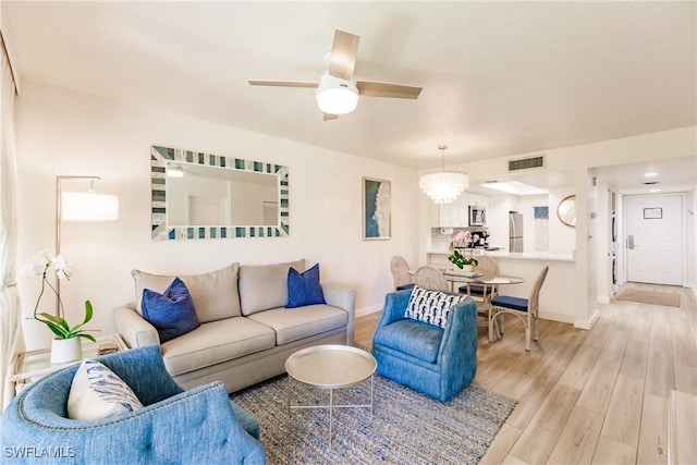 living room with ceiling fan and light wood-type flooring